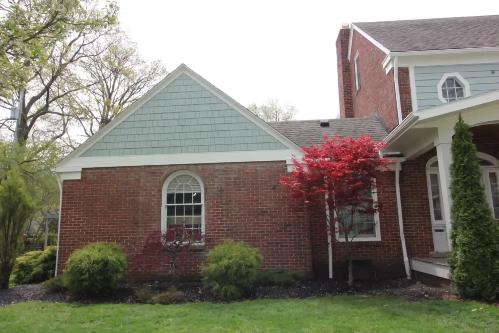 picture of garage side of house with new light blue siding recently installed.