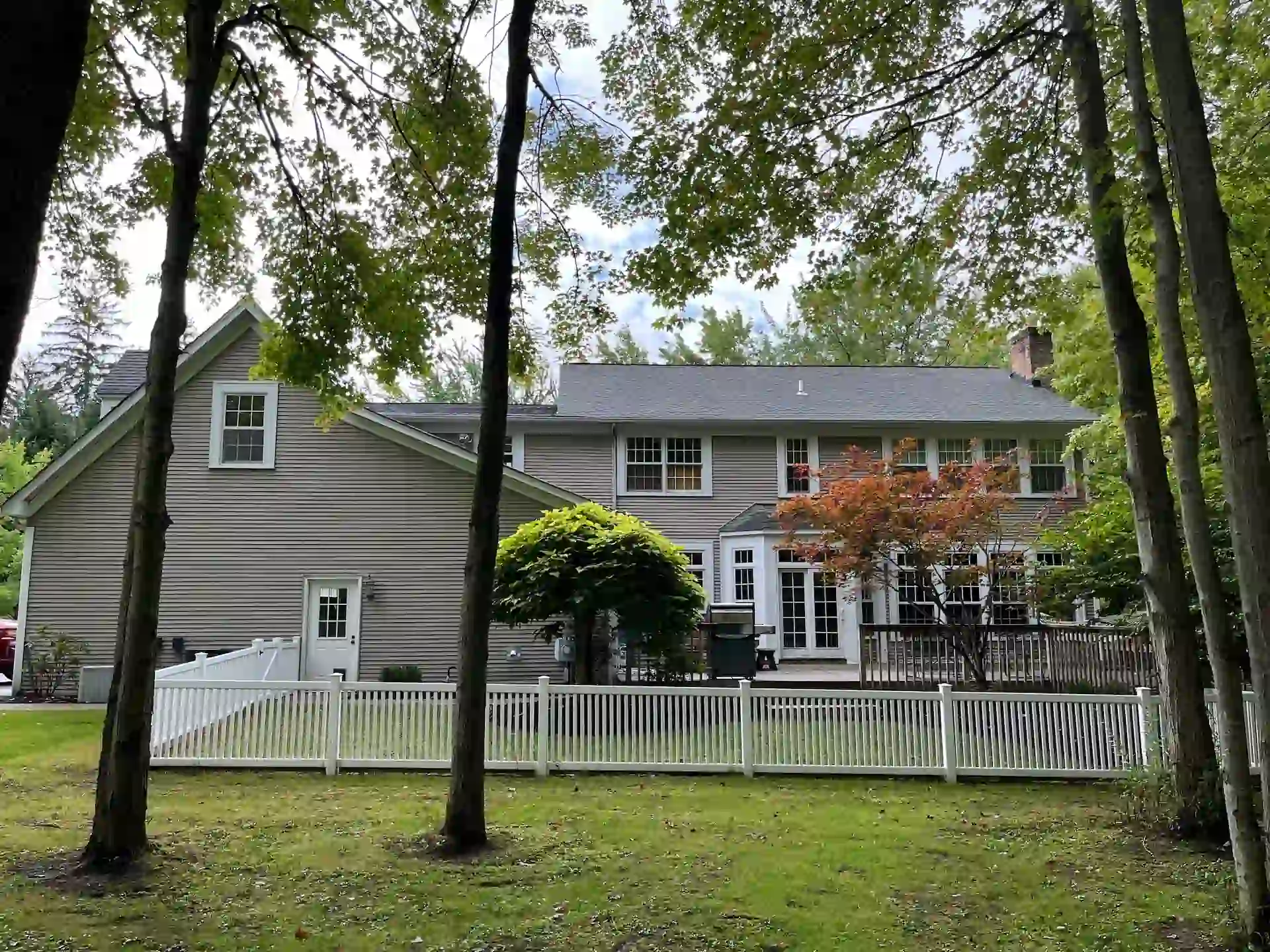 back yard of home with new tan vinyl siding