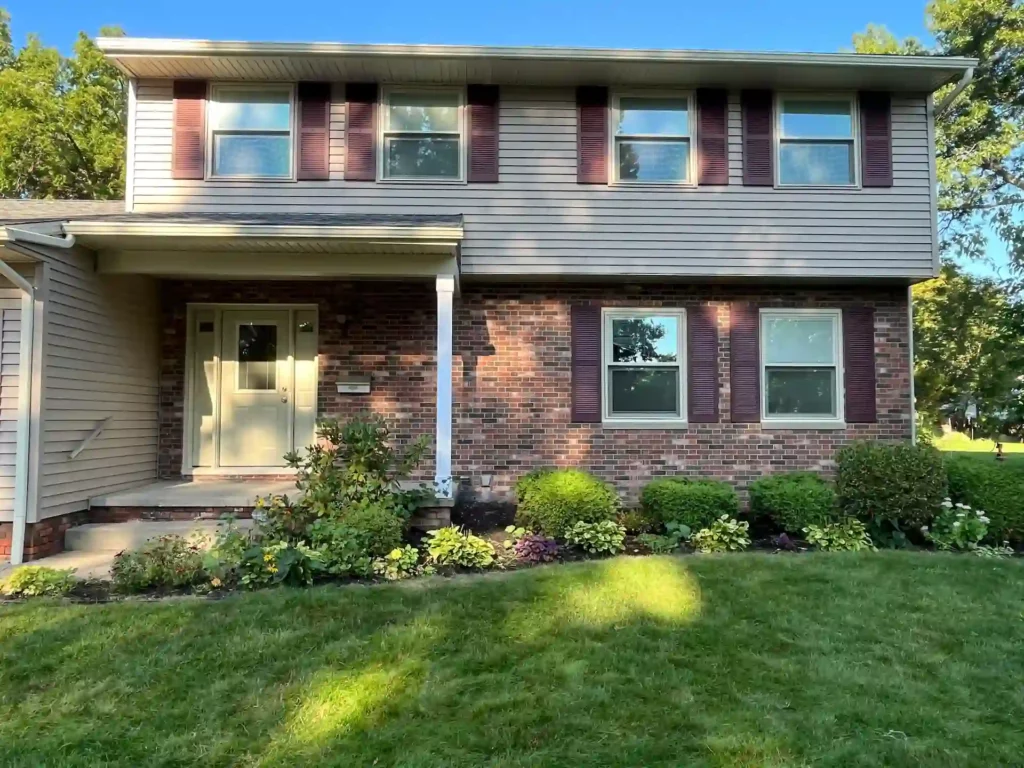 picture of a ranch style home showing new tan siding around the front door patio
