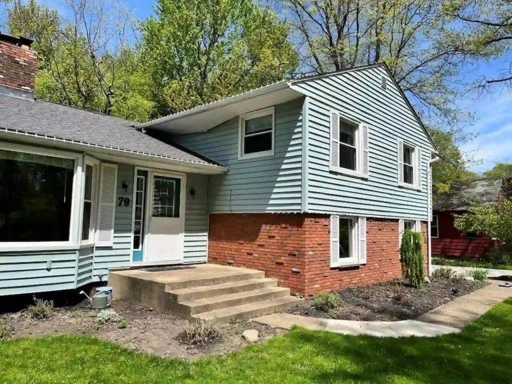 home with outdated and worn out light green vinyl siding and dirty front porch before exterior armor did any work