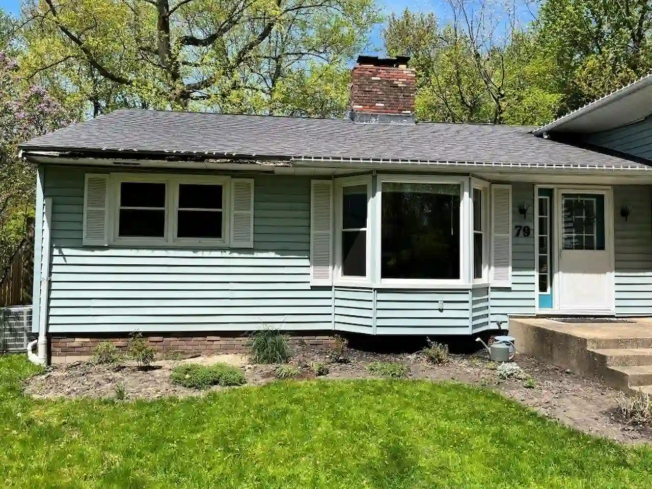 home with outdated and worn out light green vinyl siding