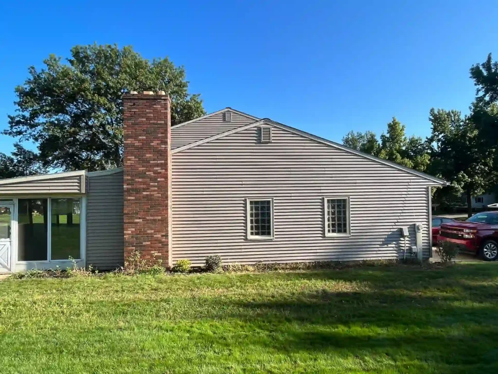 picture of a home from the back yard with new siding that was just installed. fireplace chimney in photo too.