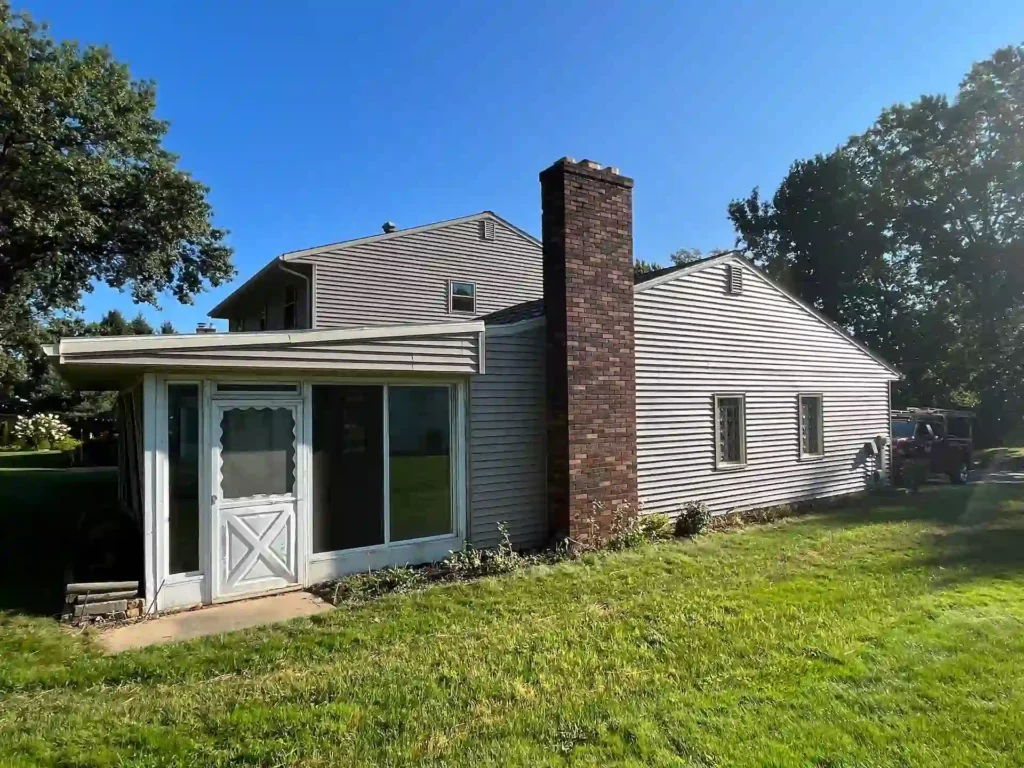 picture of a home from the back yard with old siding that needs replacing